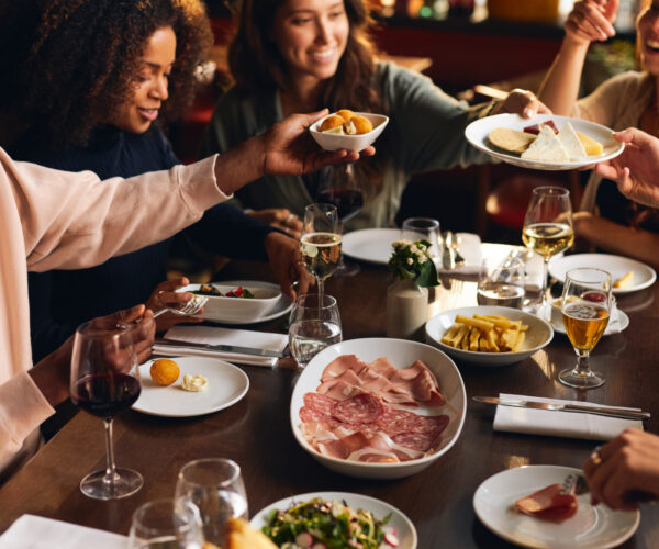 Friends sharing plates of food in restaurant